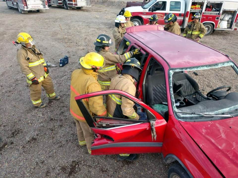 Firemen using Jaws of life to enter a vehicle